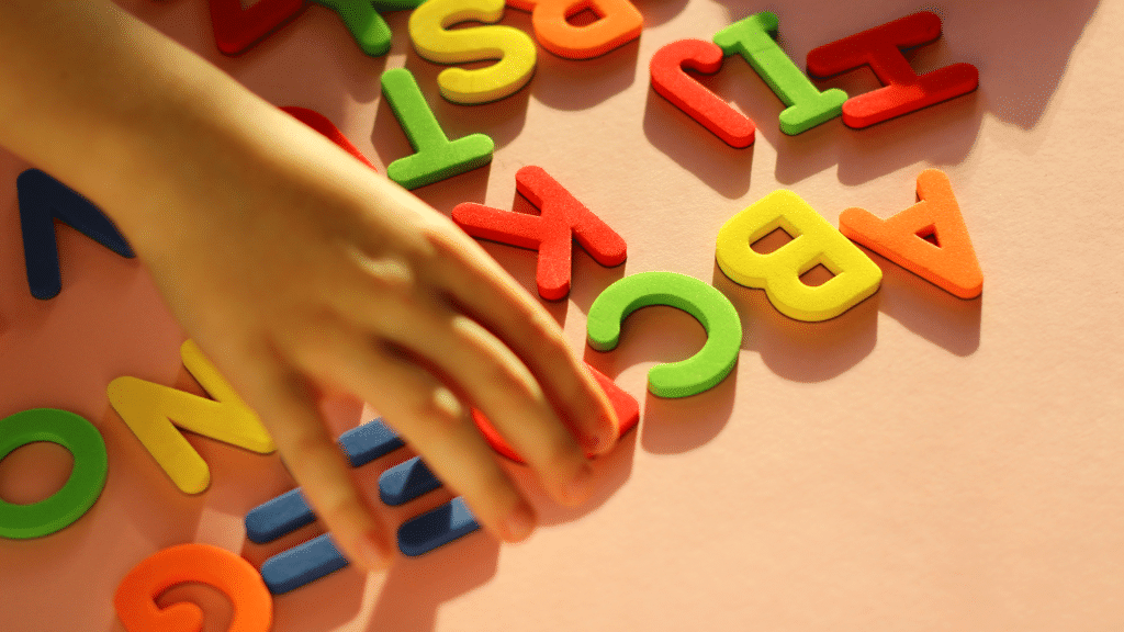 Niña explorando letras de colores mientras aprende a leer, acompañamiento inclusivo para estudiantes con dislexia